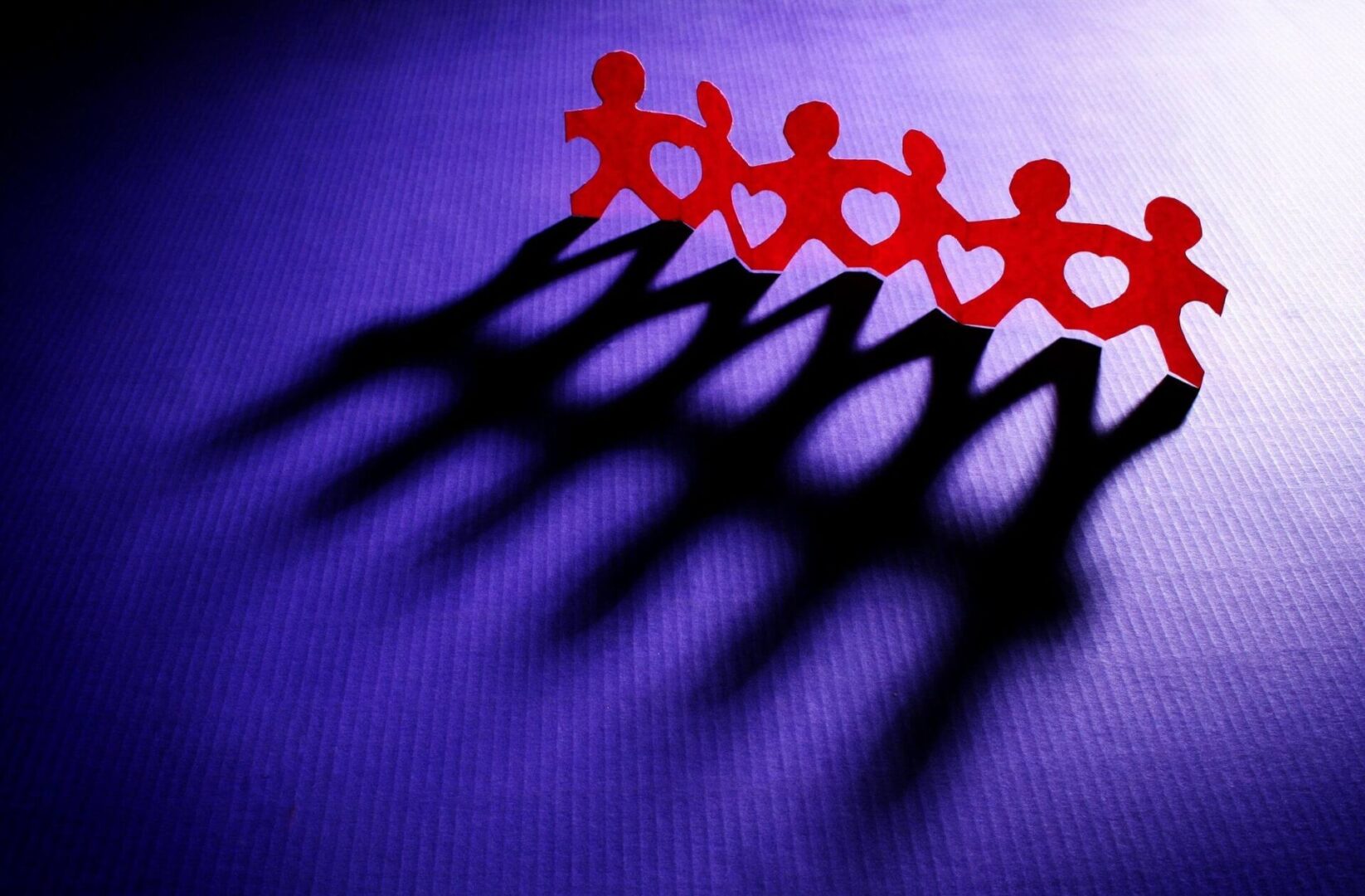 A group of people standing in the middle of a purple cloth.