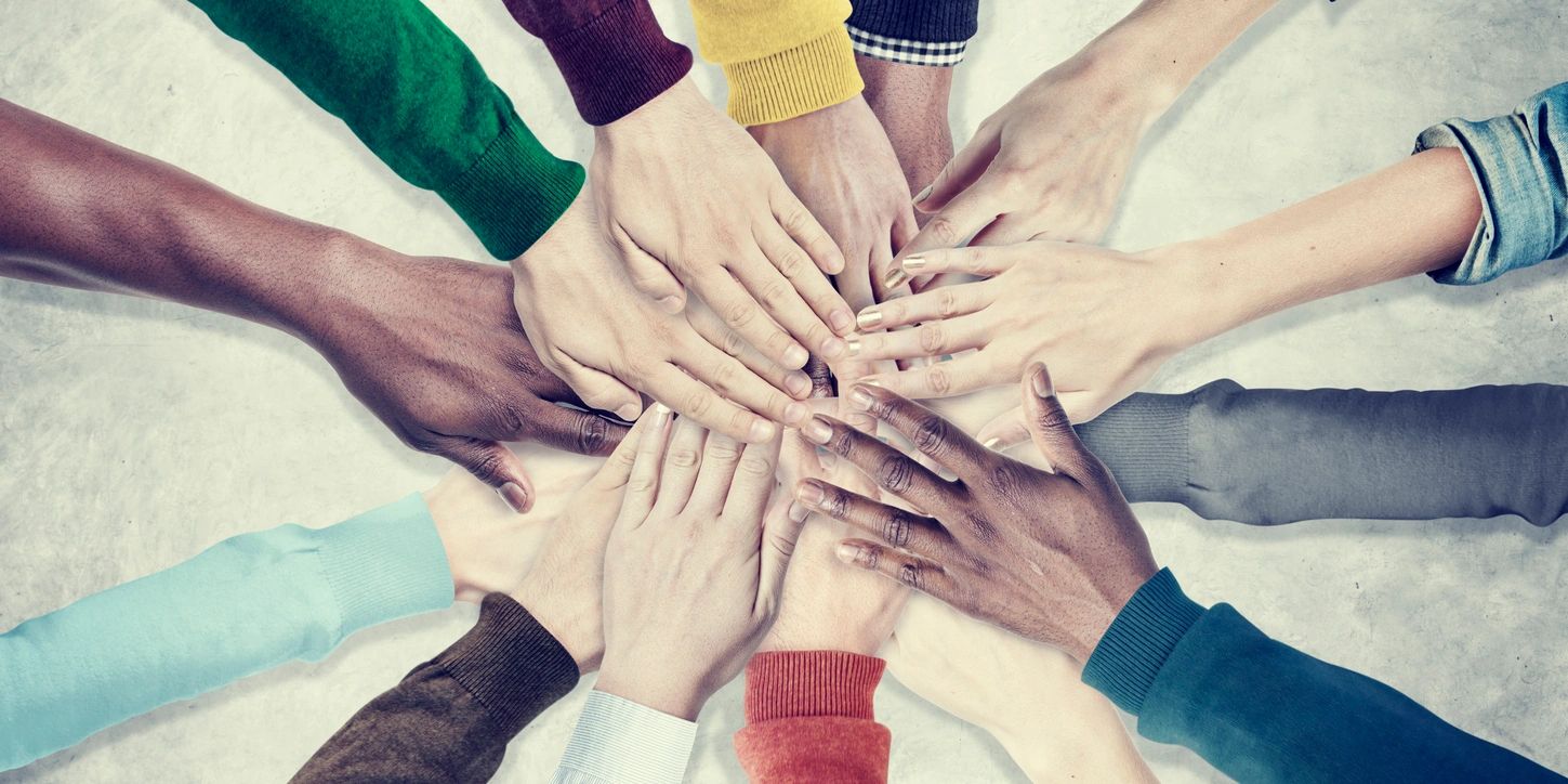 A group of people holding hands in the middle of a circle.