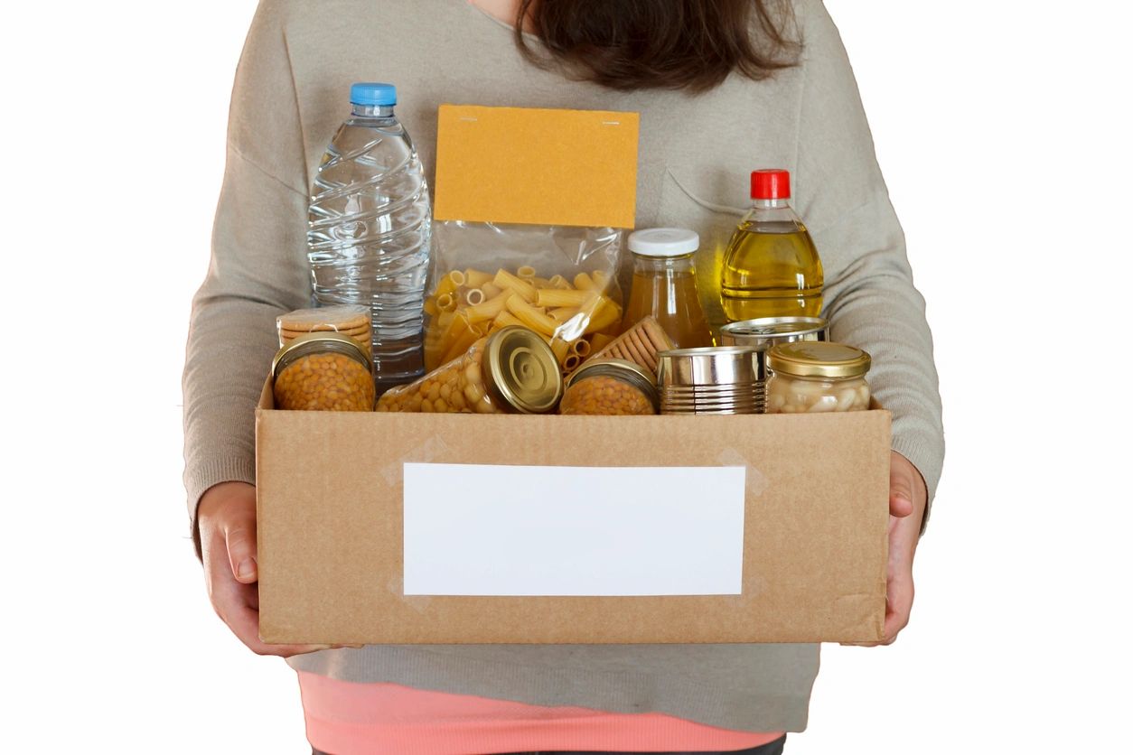 A woman holding a box of food and water.