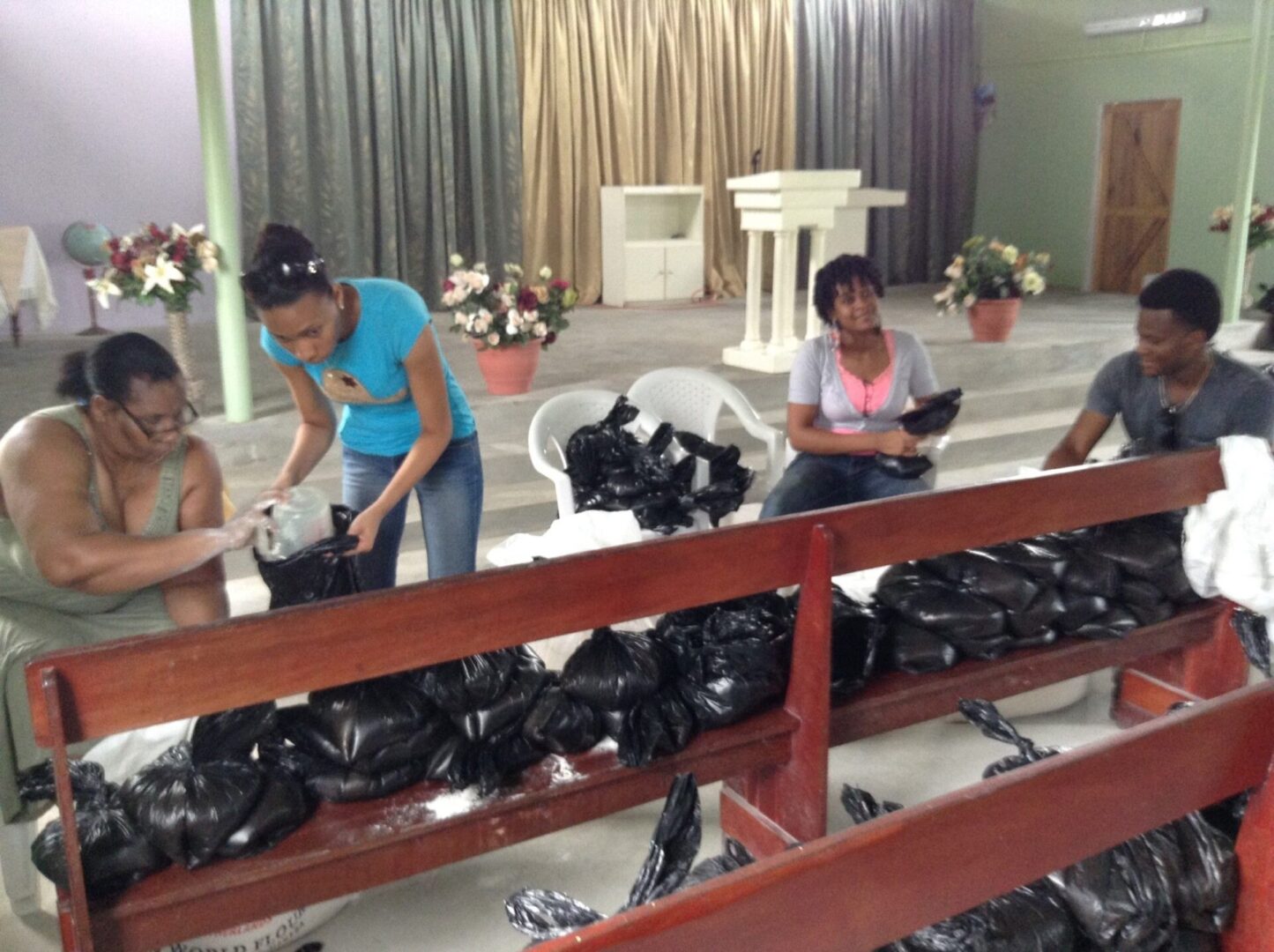 A group of people working on bags in a room.